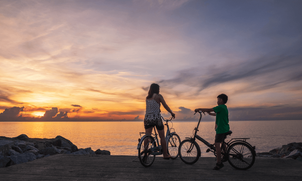 A mother and her child biking on the seashore to have a healthy life.